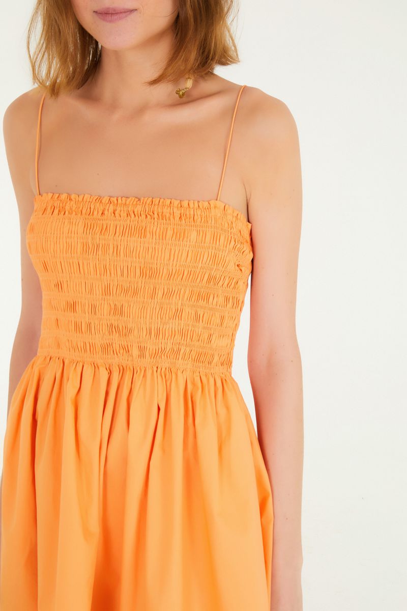 Detalle del corpiño con elástico del vestido corto naranja.