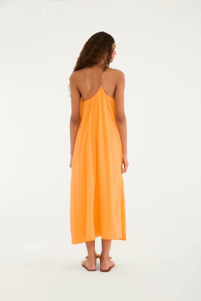 Vista lateral del vestido largo naranja con diseño de un solo hombro.