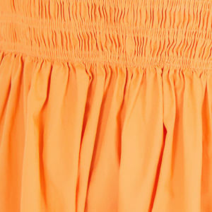 Close-up del tejido y elástico del vestido corto naranja.