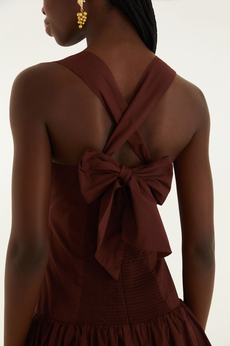 Detalle de la espalda del vestido corto estilo balón con tirantes cruzados y lazo decorativo.