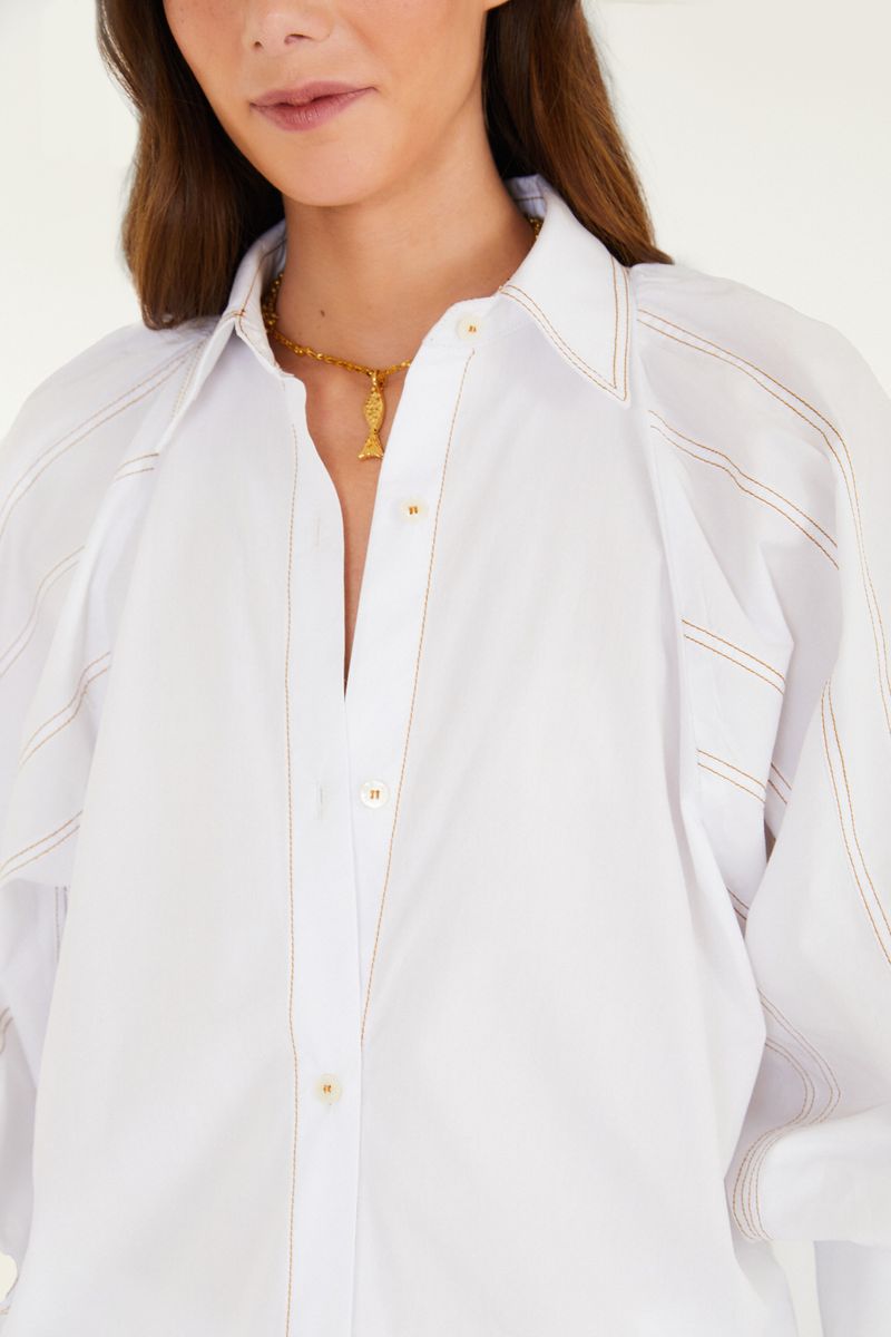 Detalle del cuello y pespuntes de la camisa blanca.