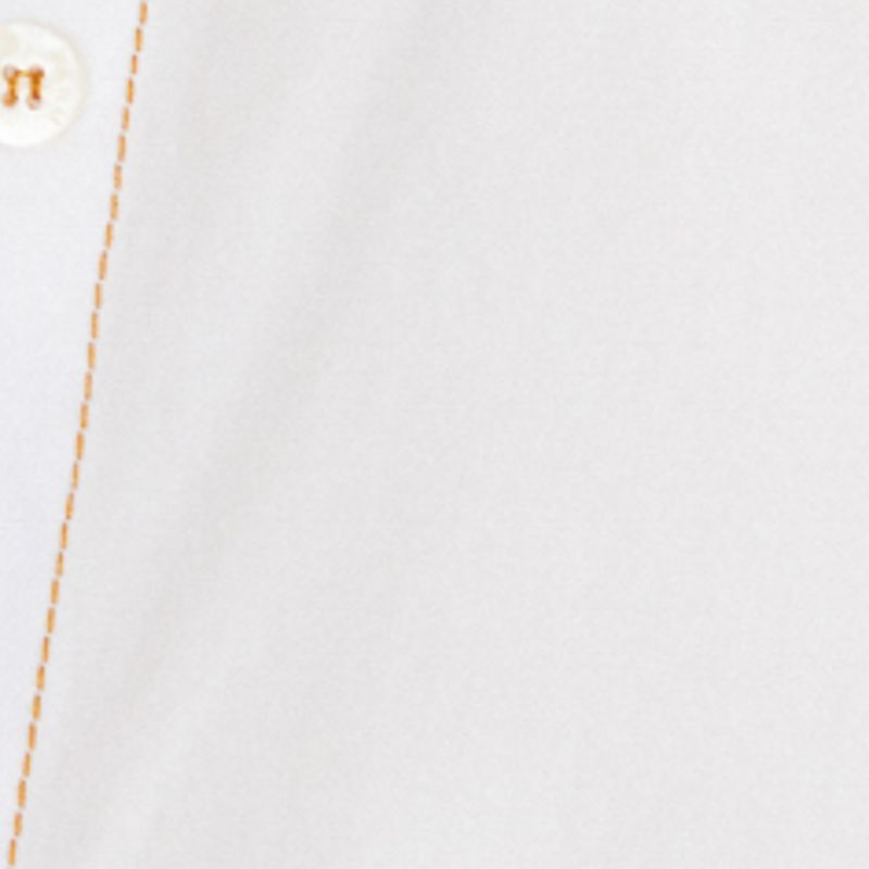 Detalle de la tela y pespuntes de la camisa blanca.