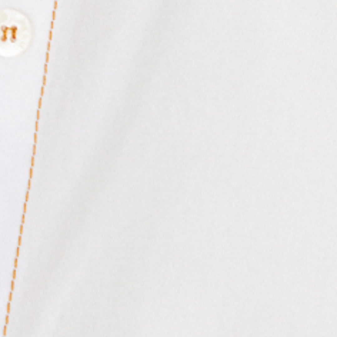 Detalle de la tela y pespuntes de la camisa blanca.
