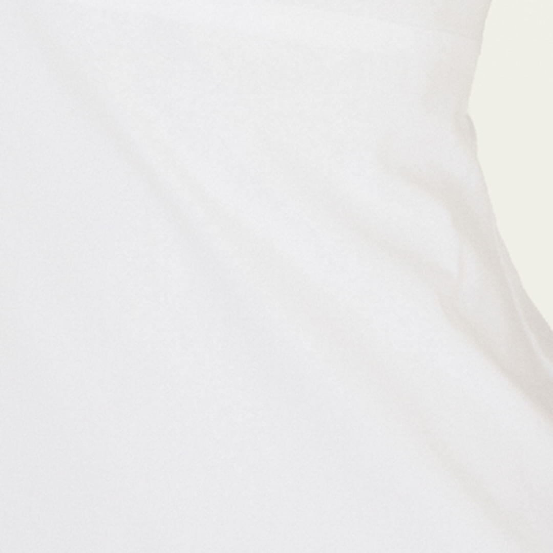 Acercamiento de la tela blanca del vestido corto balón con tirantes anchos.