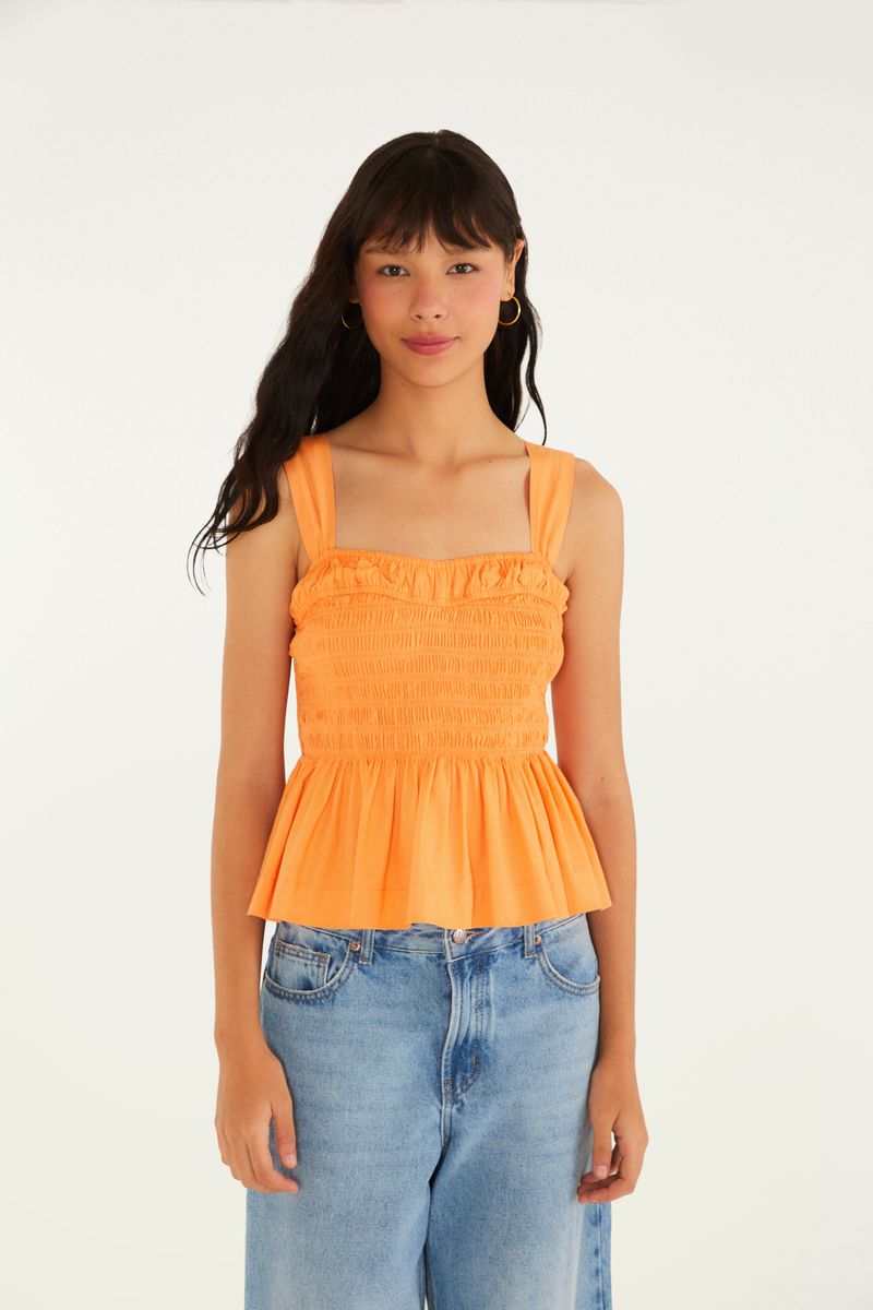 Blusa estilo peplum con lastex en vista frontal, sin mangas y con lazada en la espalda.