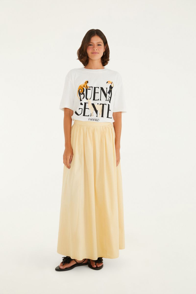 Modelo vistiendo falda larga beige con pliegues frontales, combinada con camiseta blanca.