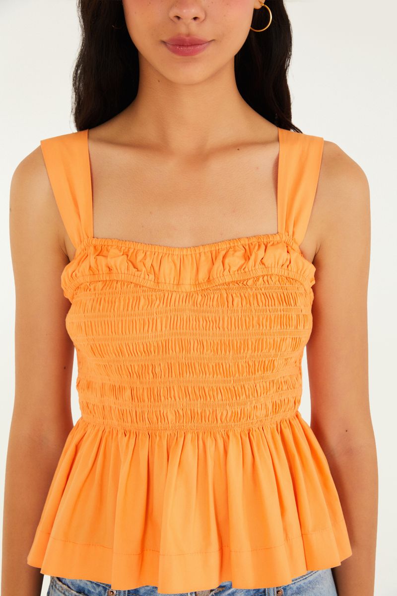 Detalle del lastex en la parte frontal de la blusa estilo peplum.