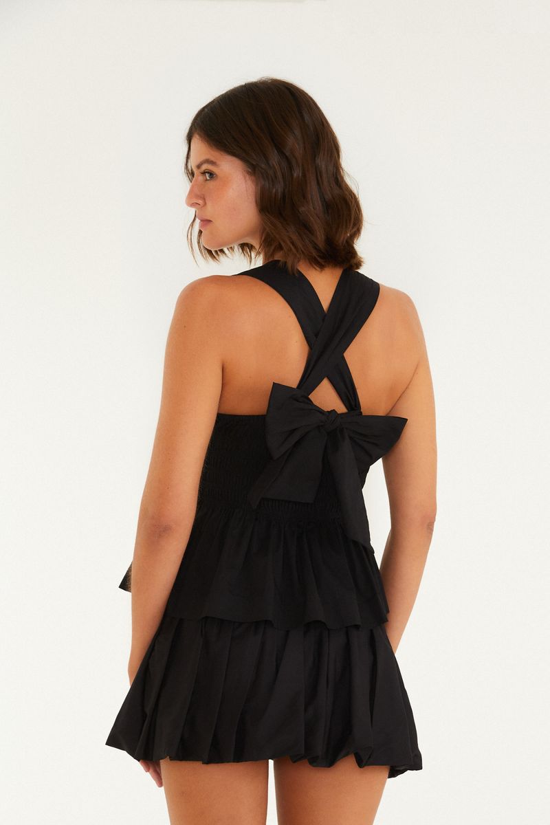 Vista trasera de la blusa negra estilo peplum con amarre.