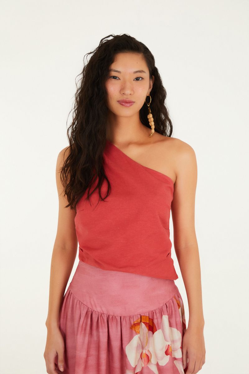 Blusa roja con diseño asimétrico y pliegues en el hombro, vista frontal.