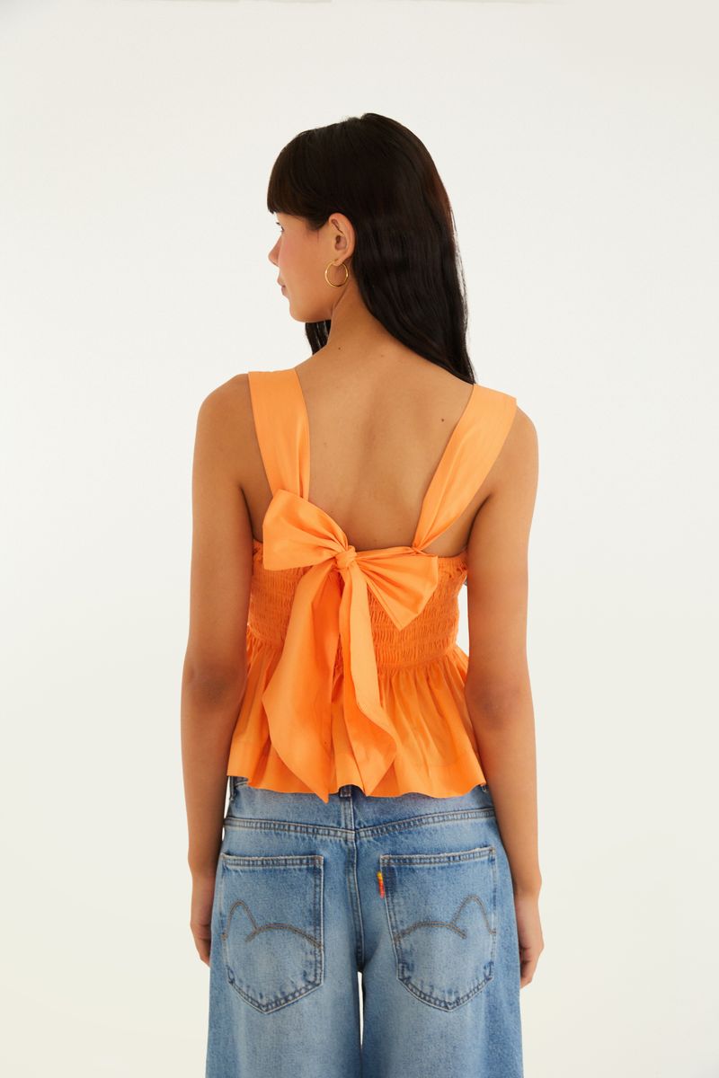 Vista trasera de la blusa estilo peplum con lazada en forma de moño.