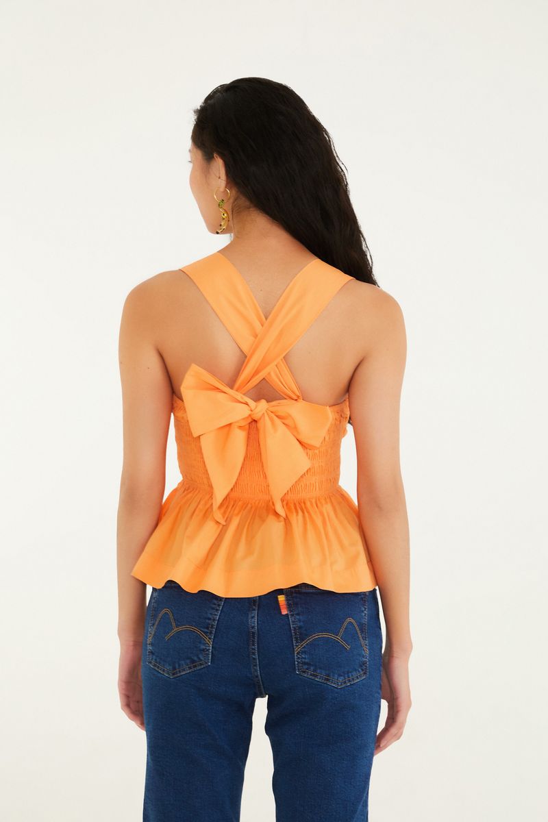Vista lateral de la blusa estilo peplum mostrando el ajuste al cuerpo.