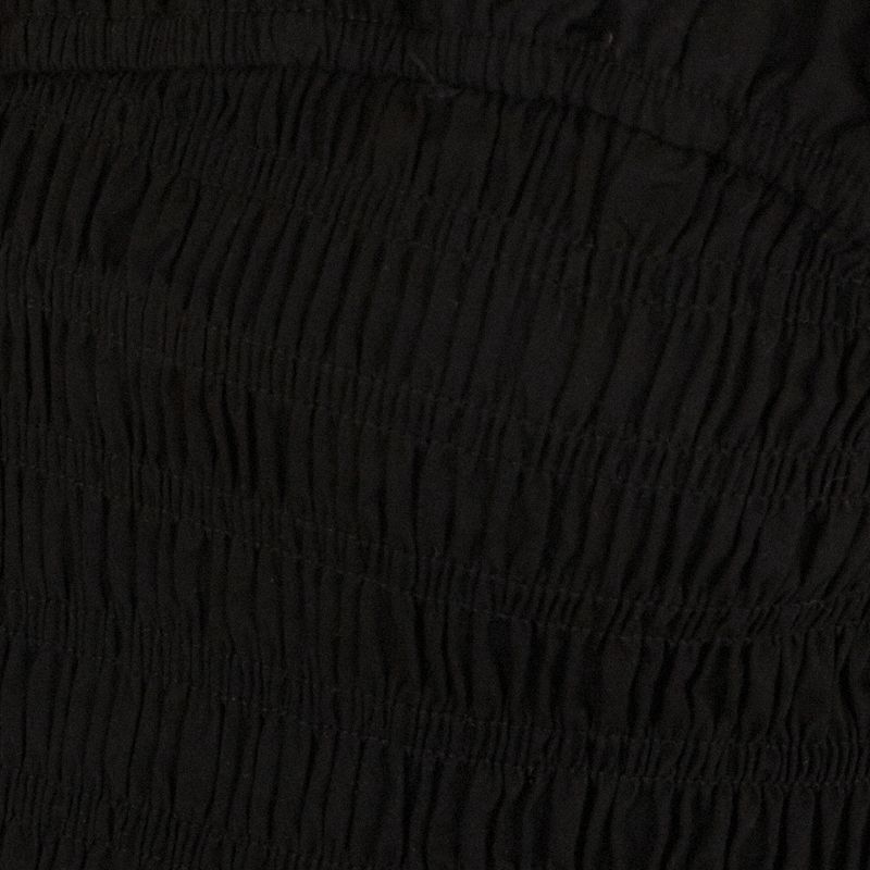 Primer plano del tejido lastex de la blusa negra estilo peplum.
