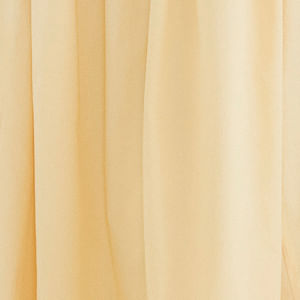Modelo vistiendo falda larga beige con pliegues frontales, combinada con camiseta blanca.