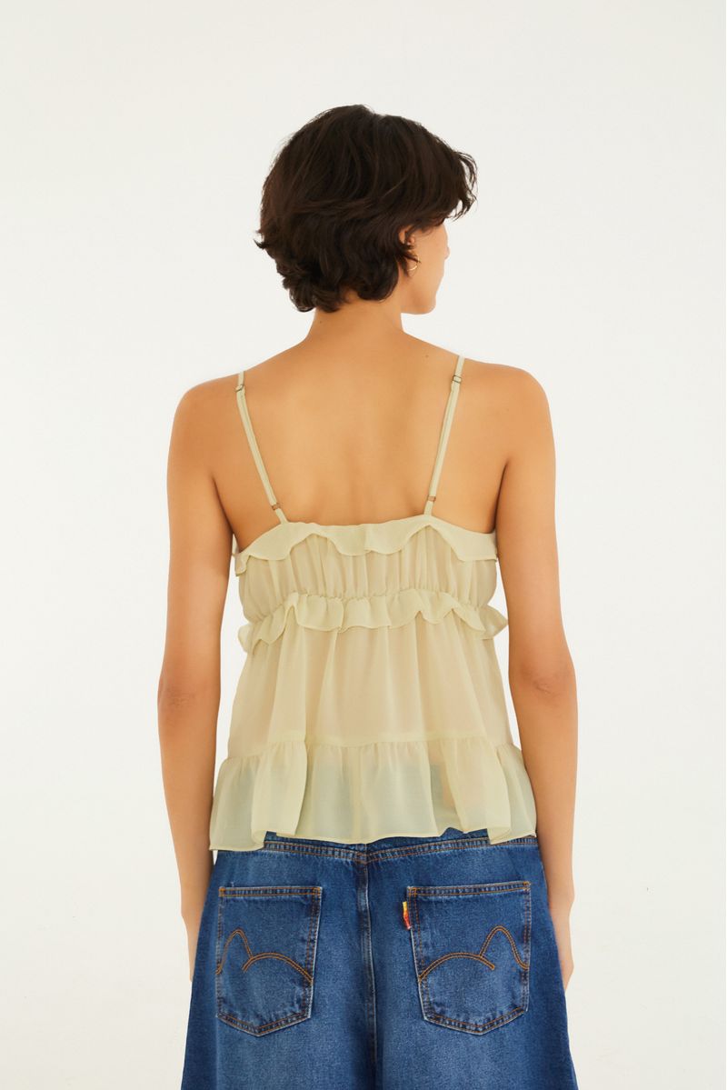 Blusa femenina con volantes y tiras, vista lateral.