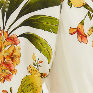 Primer plano del estampado tropical con elementos botánicos y aves.