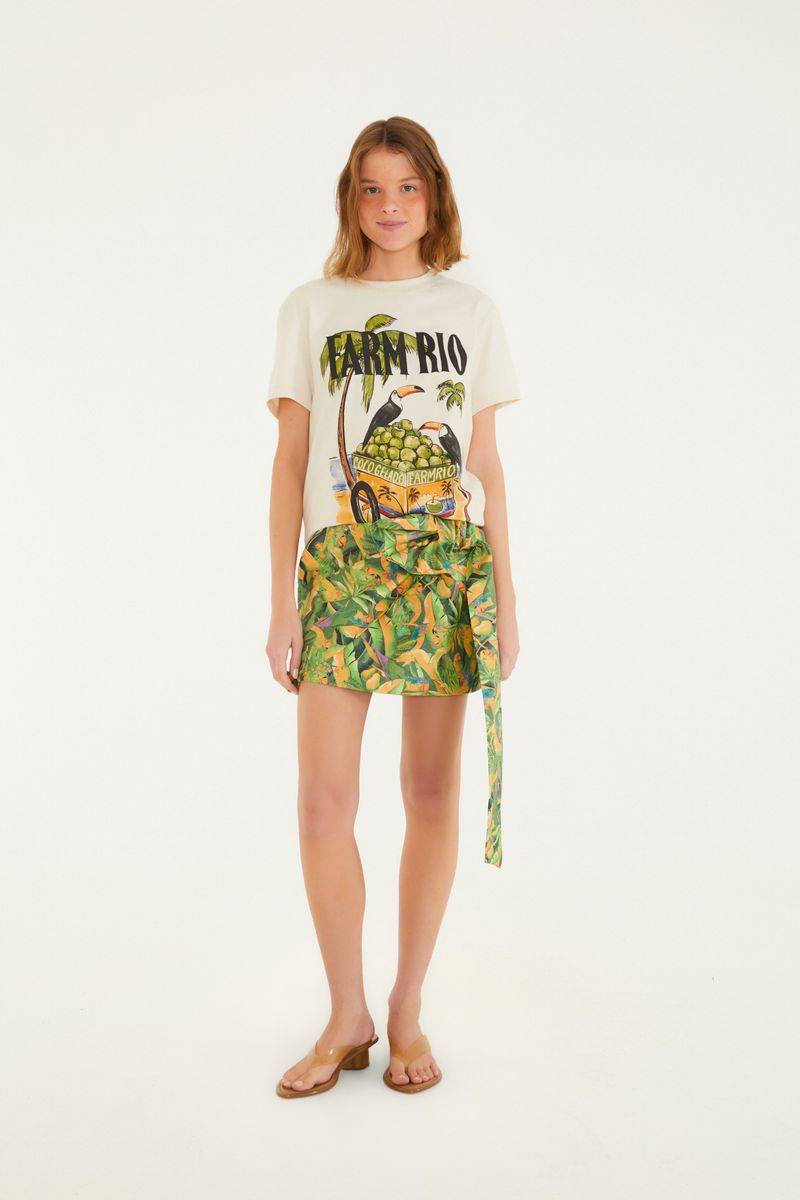 Imagen de una falda corta con estampado tropical de hojas y pájaros, vista frontal.