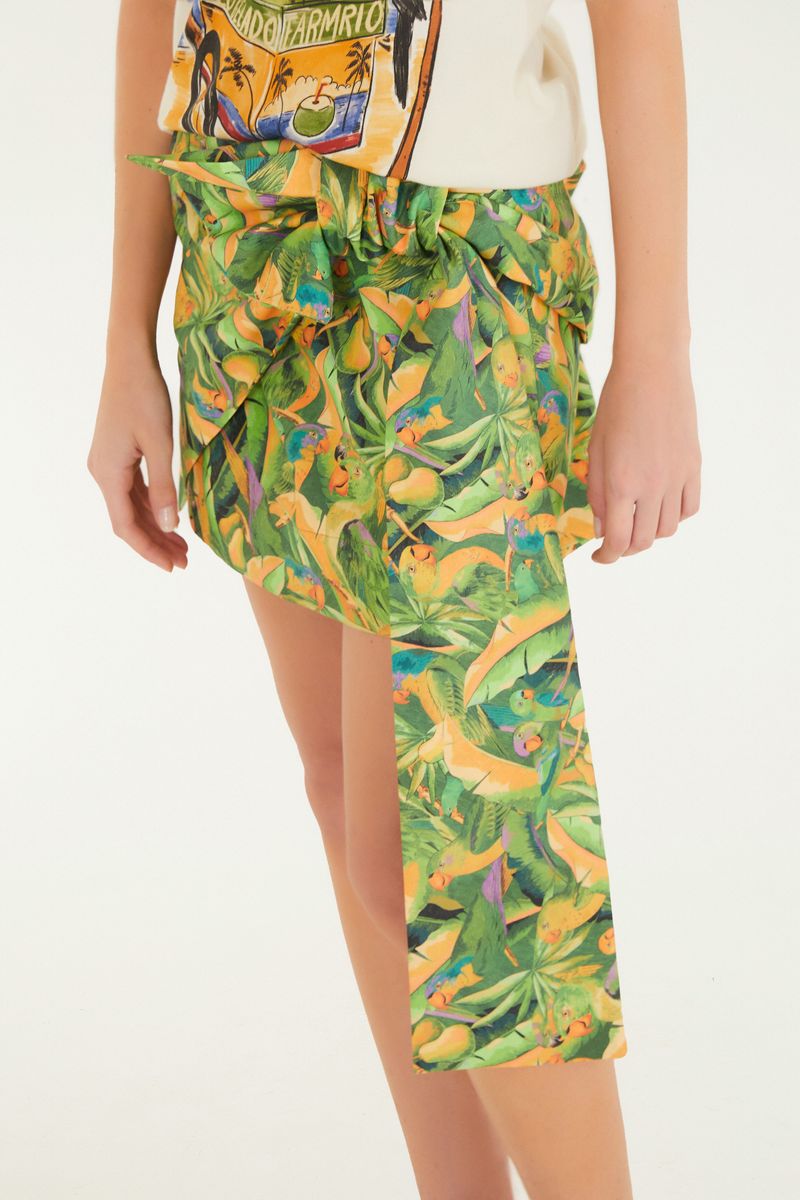 Detalle del ajuste en la cintura de la falda con estampado tropical.