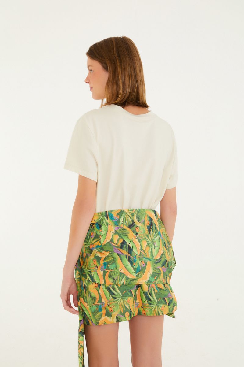 Vista lateral de la falda con estampado tropical mostrando el diseño cruzado.