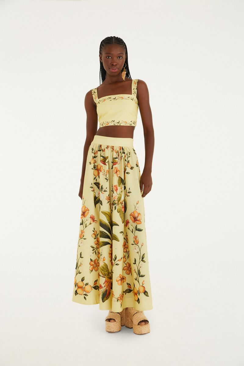 Modelo lleva una falda larga estampada con motivos botánicos y florales, vista frontal.