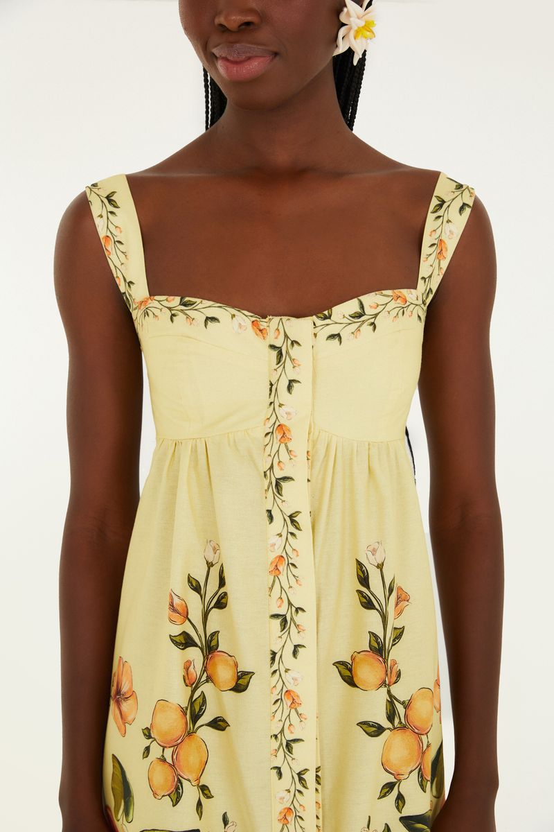 Primer plano del corpiño del vestido mostrando detalles del estampado botánico y frutas.
