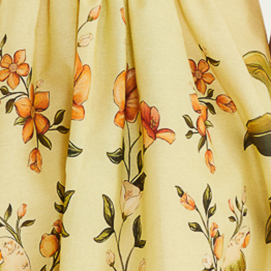Primer plano del estampado floral en la falda del vestido mostrando flores y hojas.