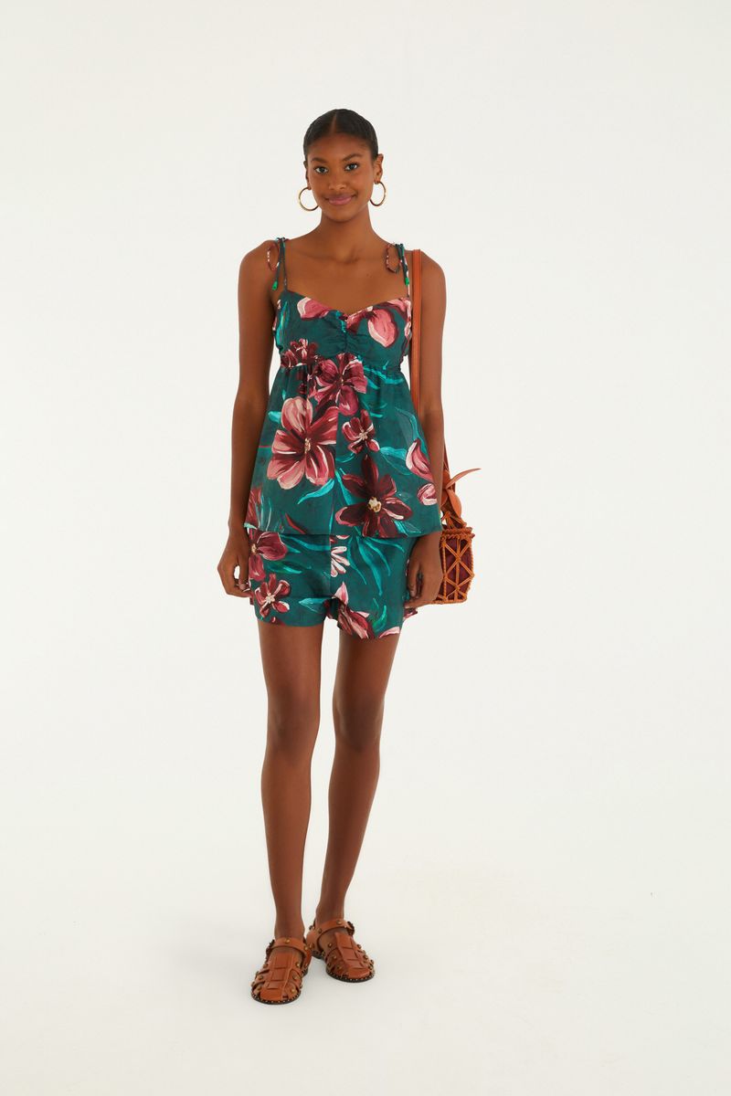 Modelo usando el Short Lineia con estampado floral tropical en rojo y verde oscuro, combinado con una blusa de tirantes.