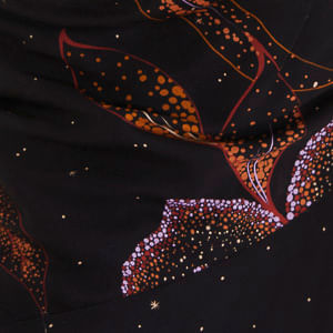 Vista trasera de la blusa con bajo redondeado y estampado completo.