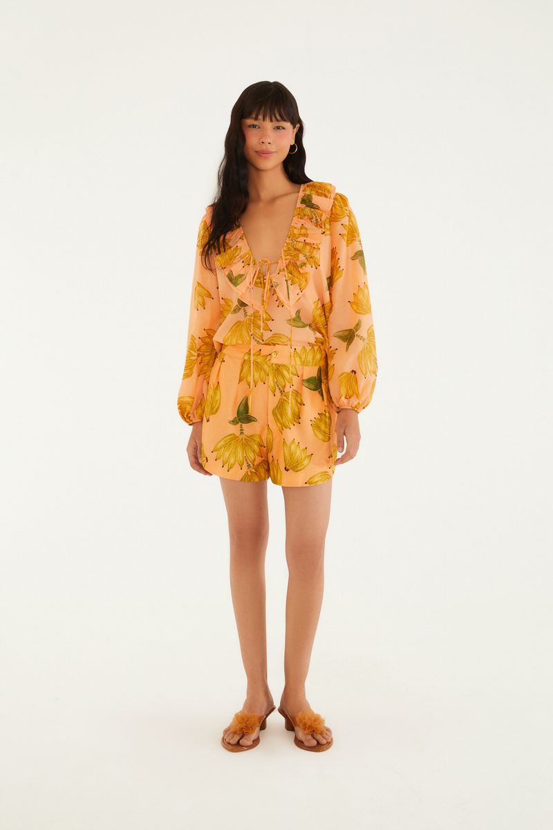Modelo usando conjunto con estampado tropical, incluyendo short y blusa.