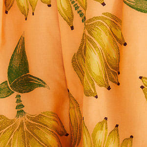 Close-up del estampado tropical con bananas sobre fondo naranja.