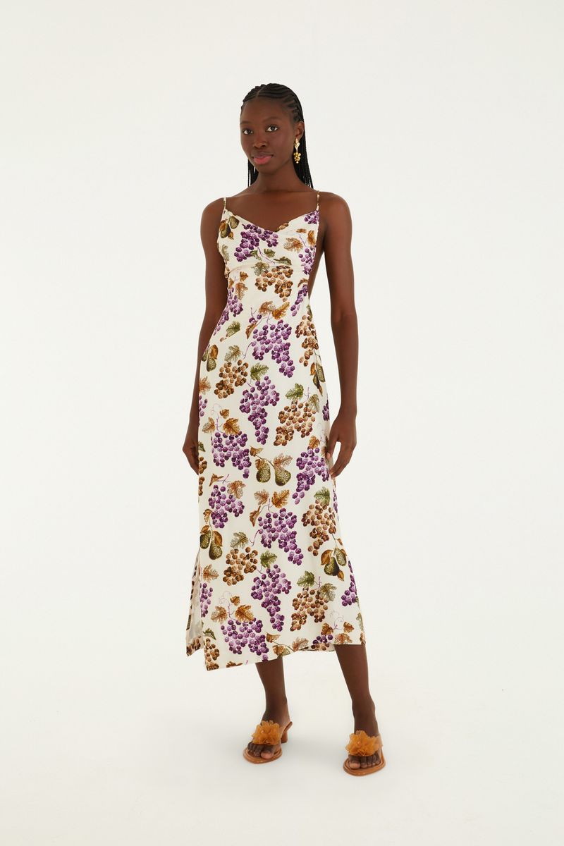 Vestido largo con tirantes finos, estampado de uvas y hojas sobre fondo claro, visto de frente.
