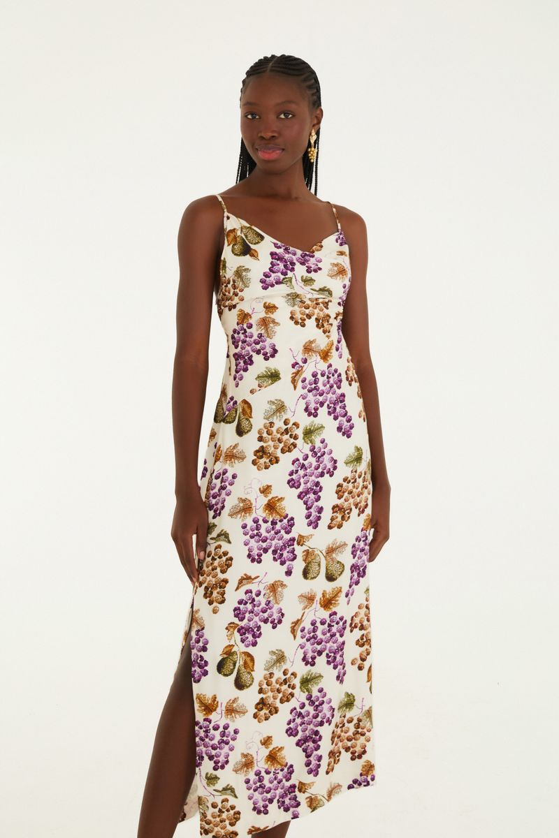 Vestido largo con tirantes finos, estampado de uvas y hojas sobre fondo claro, detalle lateral.