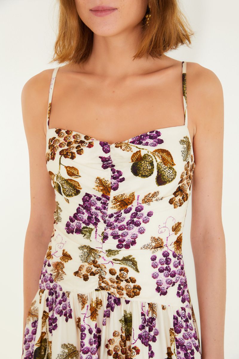 Imagen frontal de un vestido corto con estampado de uvas y hojas, tiras delgadas y escote en forma de corazón.