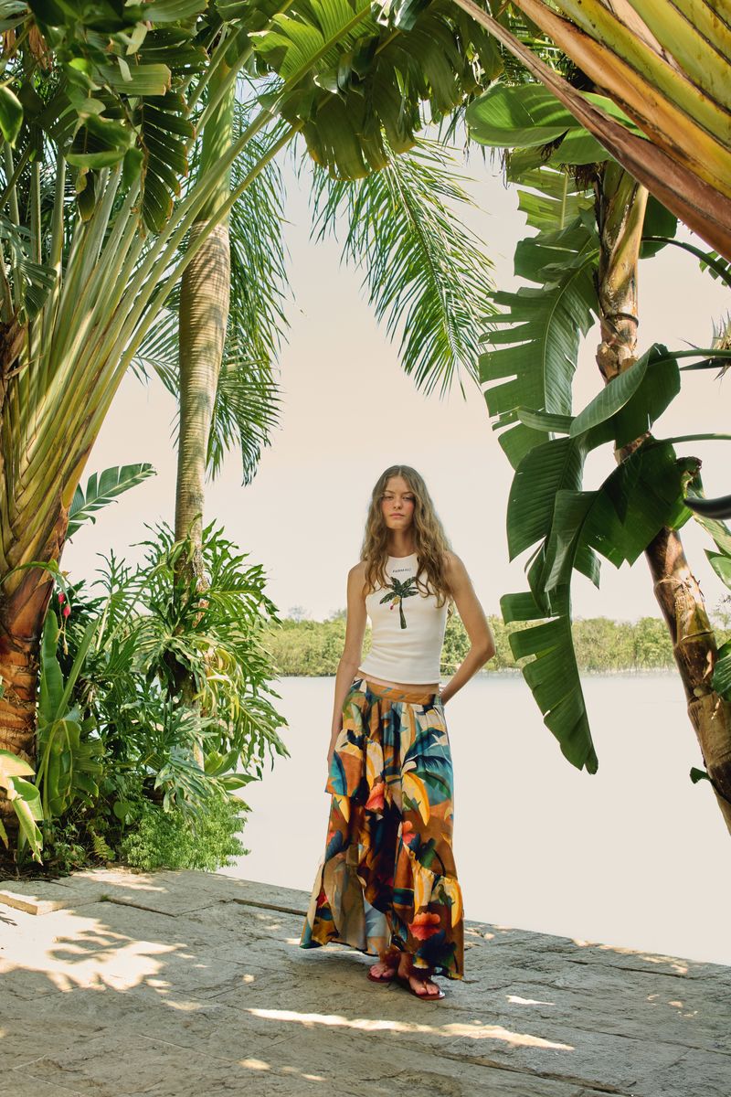 Modelo usando short estampado tropical en espacio al aire libre con vegetación exuberante.