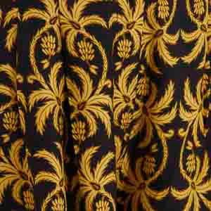 Acercamiento al estampado tropical en negro y dorado del pantalón.