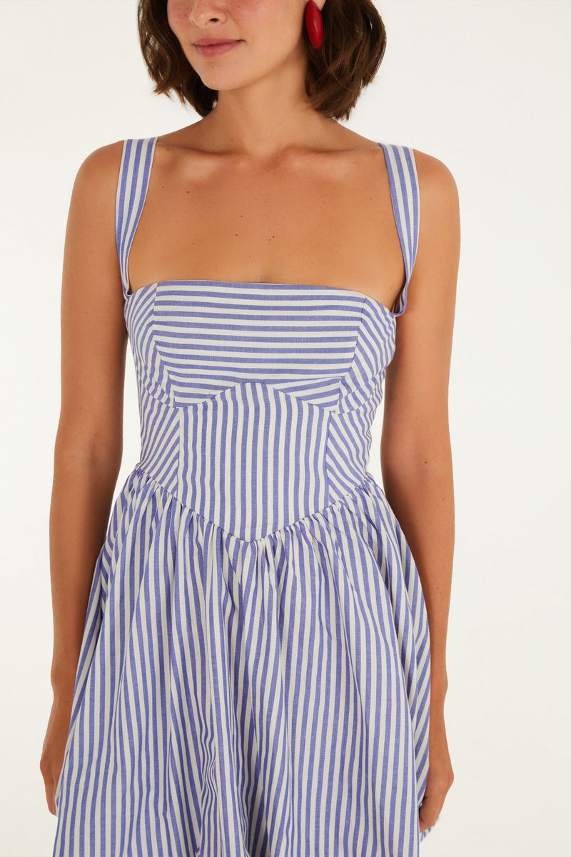 Imagen que muestra un vestido con estampado de rayas azules y blancas, con tirantes anchos y escote cuadrado, visto de frente en detalle.