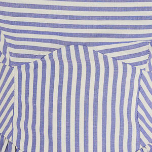 Imagen que muestra un detalle del estampado de rayas azules y blancas del vestido, con enfoque en la tela y el patrón.