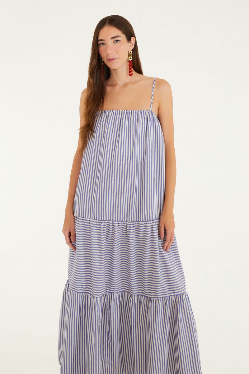 Vista trasera del vestido largo con estampado de rayas azules y blancas, mostrando el diseño fluido.