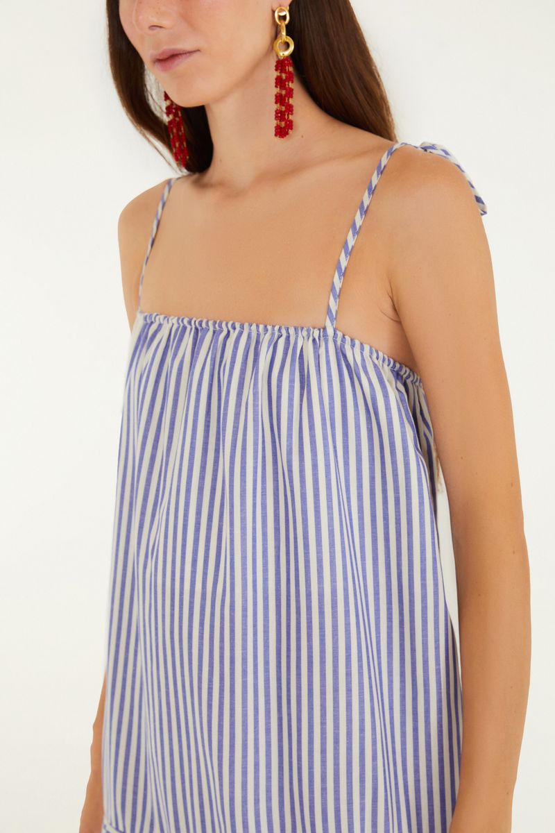 Detalle de los tirantes delgados del vestido con estampado de rayas azules y blancas.