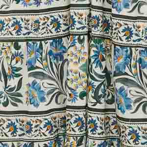 Detalle del estampado floral del vestido con elementos botánicos en azul y verde.