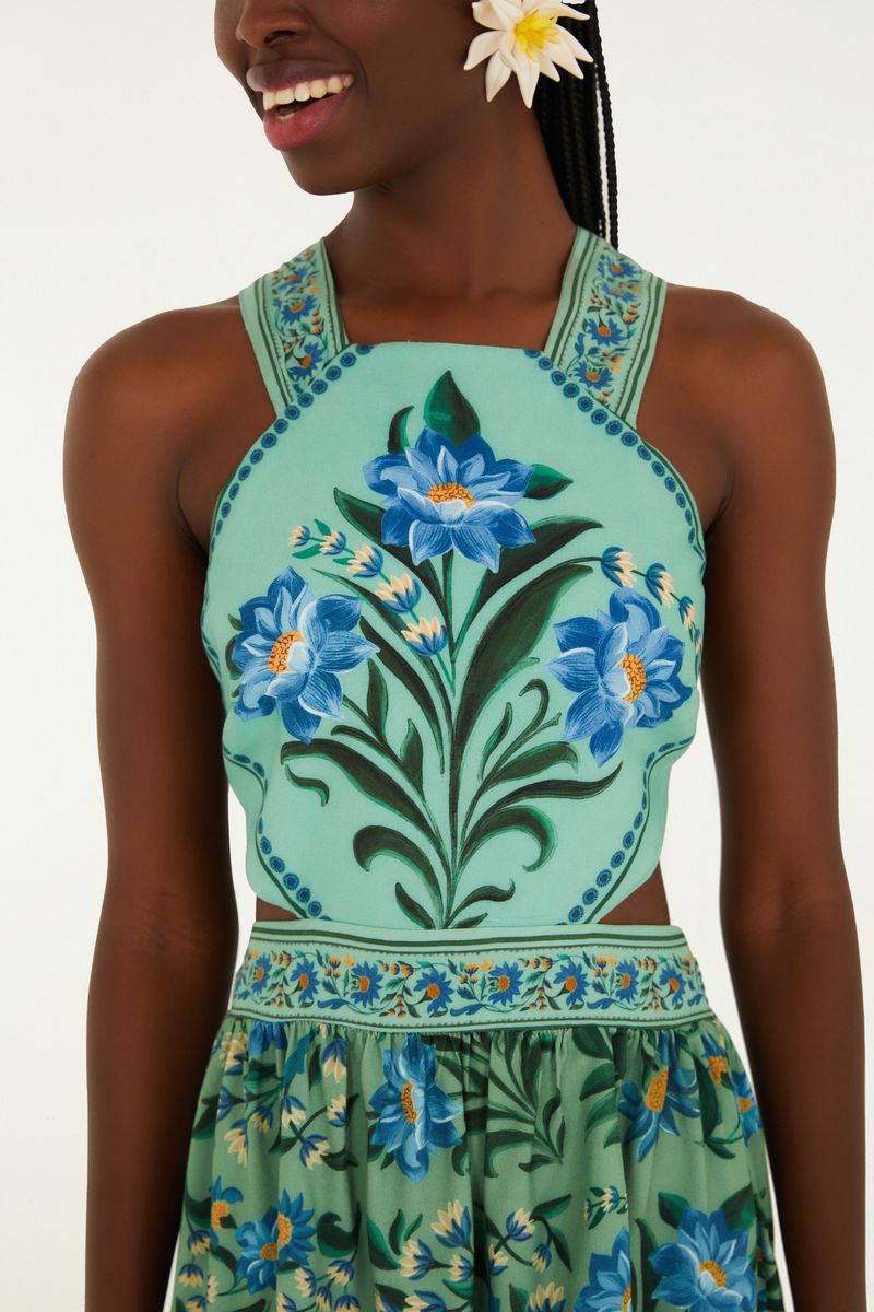Detalle del corpiño del vestido mostrando el estampado floral azul con fondo verde.