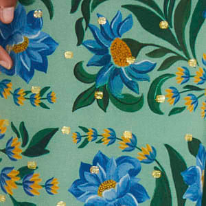 Primer plano del patrón floral del pantalón, mostrando detalles en azul, verde y amarillo.