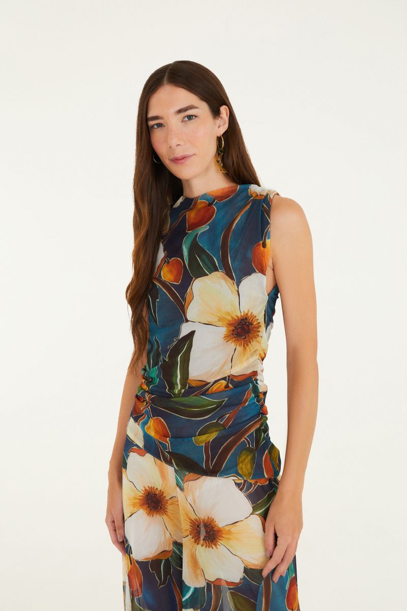 Blusa estampada floral botánica en fondo azul oscuro, vista frontal.