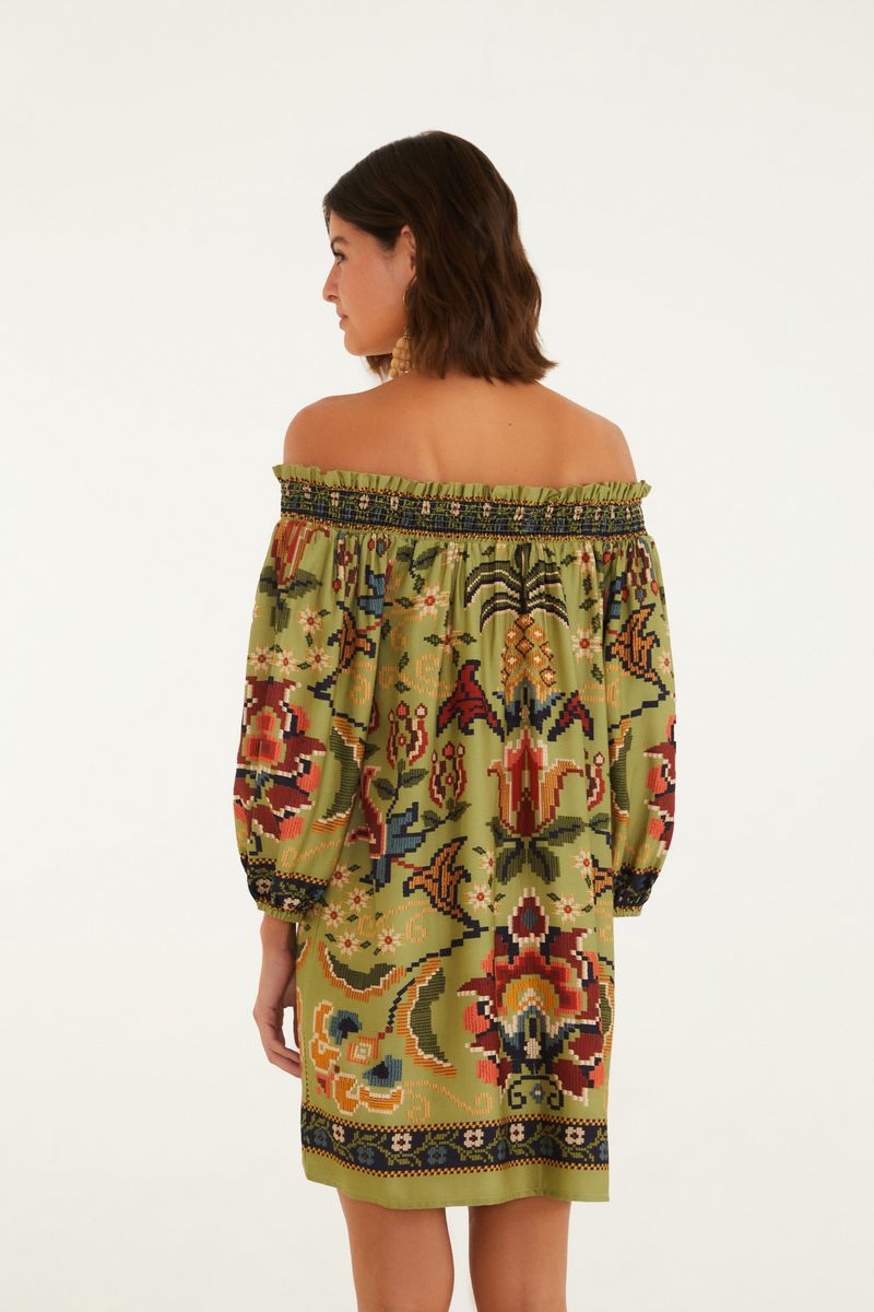 Imagen mostrando la parte trasera del vestido corto con estampado floral y geométrico, destacando el escote hombro a hombro y el largo por encima de la rodilla.