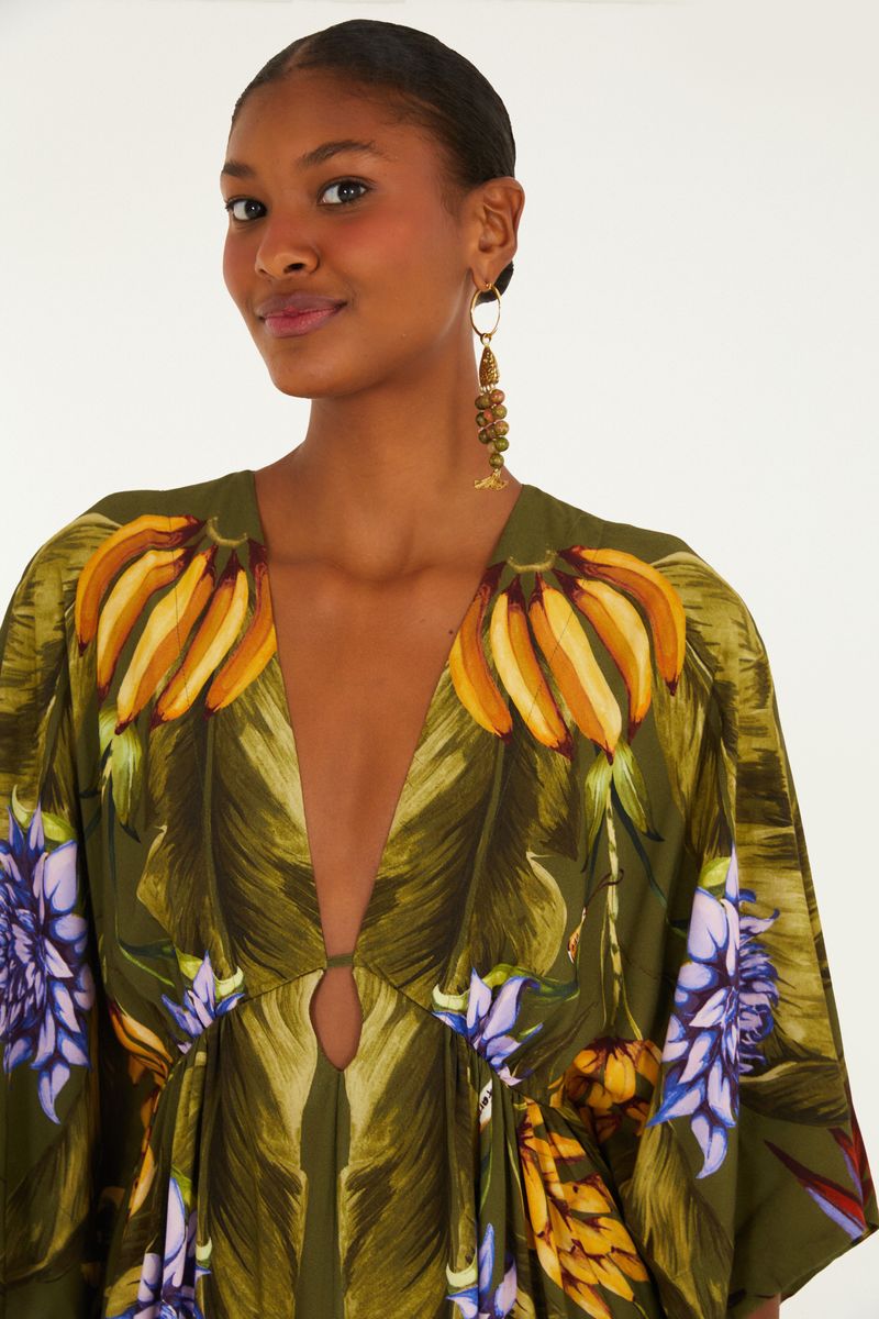 Detalle del escote profundo del vestido con estampado tropical.