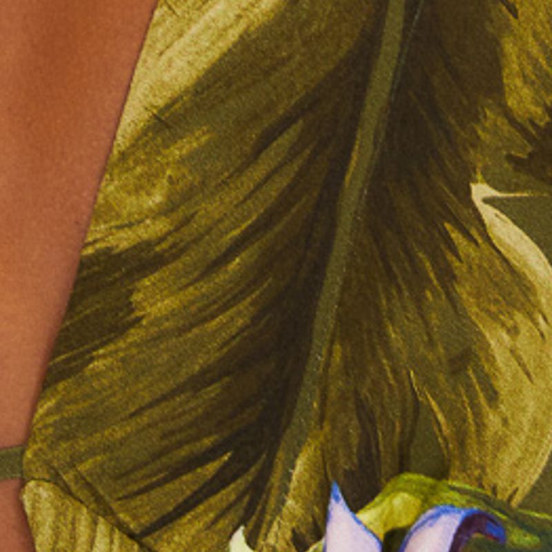 Primer plano del estampado tropical del vestido mostrando detalles de hojas y flores.