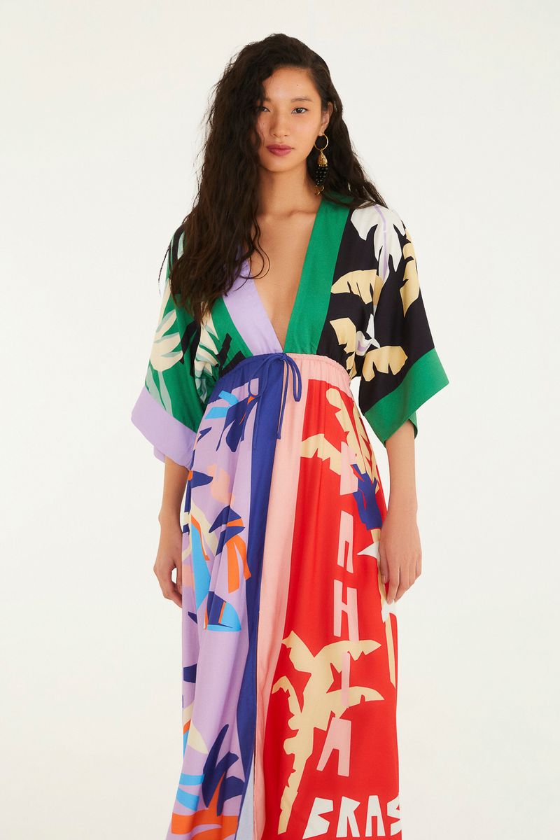Vestido cropped con estampado vibrante, escote profundo y mangas largas, visto de lado.
