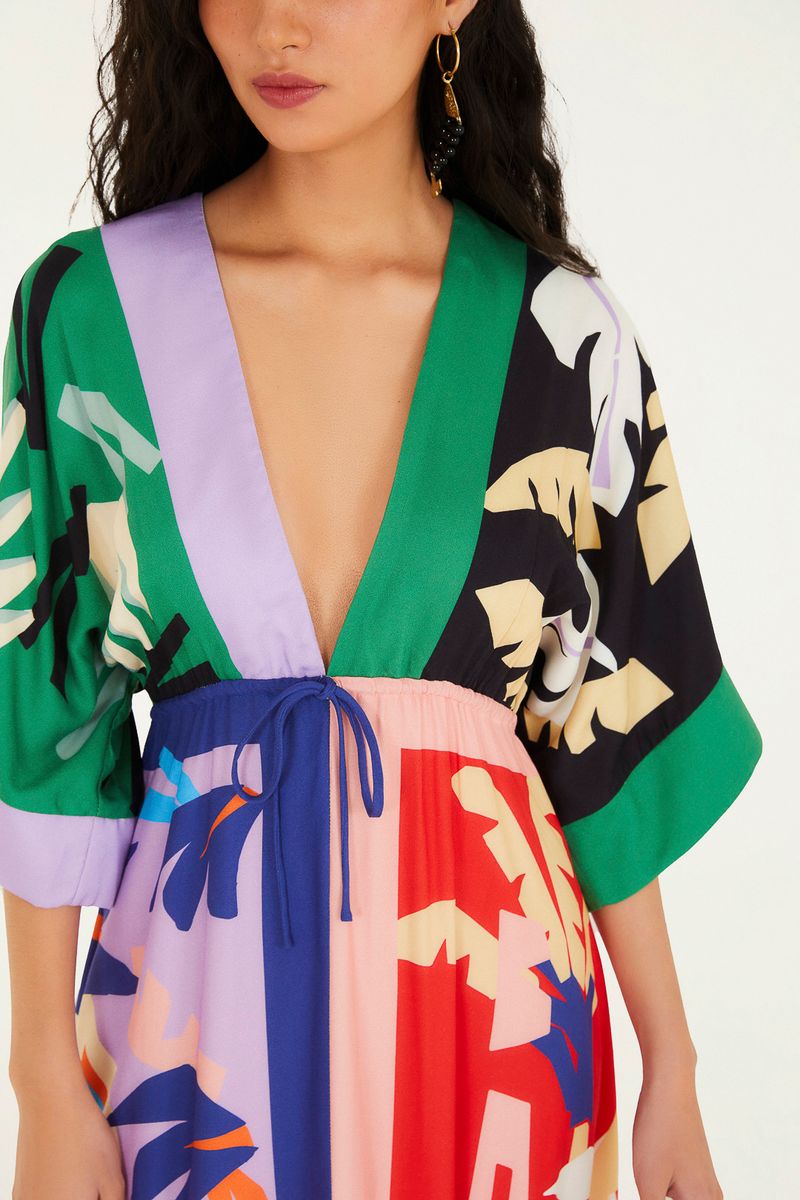 Detalle del escote profundo del vestido cropped con estampado vibrante.
