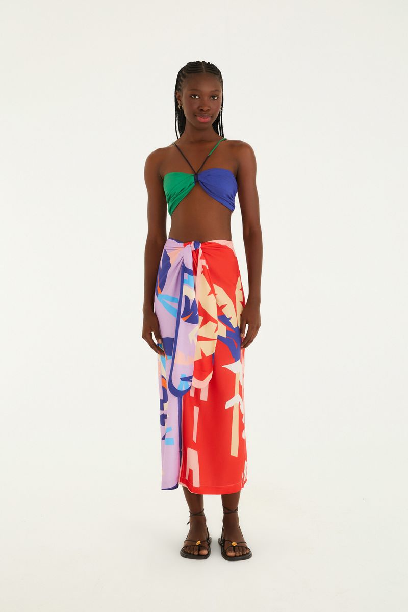 Top vibrante con diseño moderno y amarre estiloso, combinado con falda estampada.