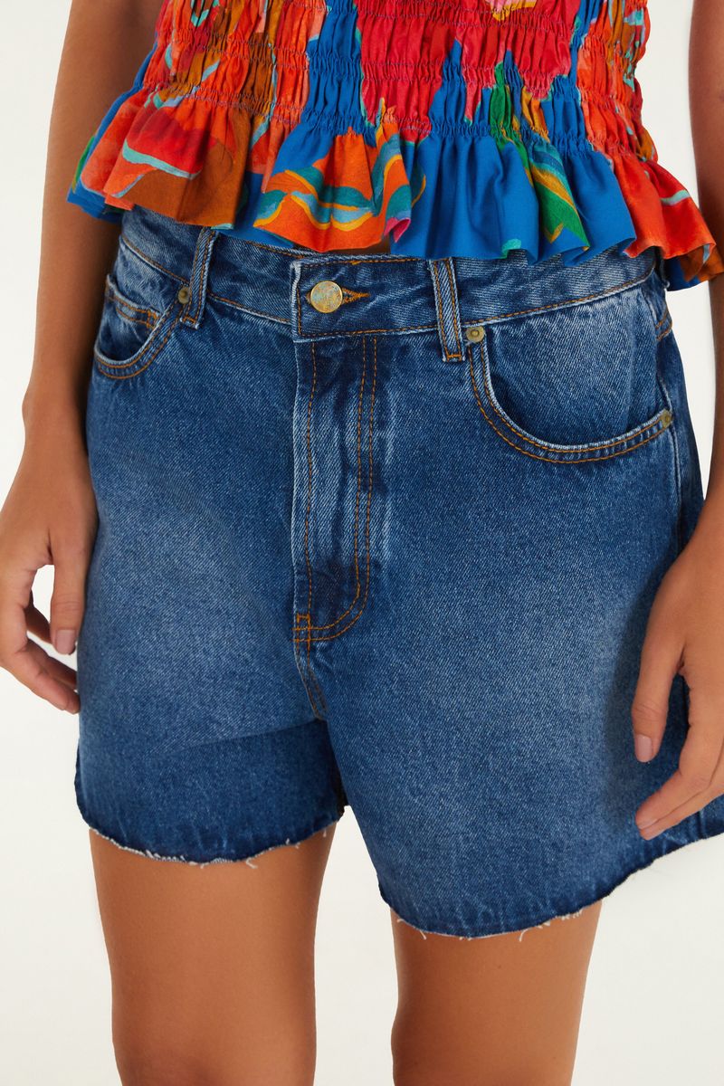 Acercamiento al short de mezclilla azul oscuro mostrando detalles del cinturón y bolsillos frontales.