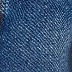 Detalle de la tela del short de mezclilla azul oscuro mostrando la textura del material.